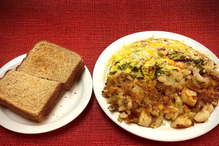 Our vegetable and cheese omelette with home fries, and toast on a side plate